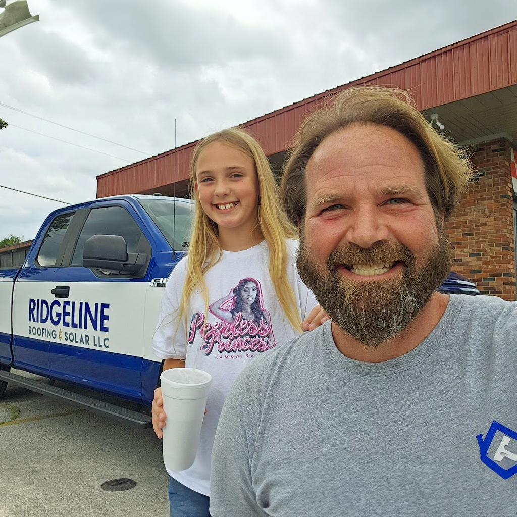 An image of Josh Brown, Project Manager for Ridgeline Roofing standing just in front of his daughter.